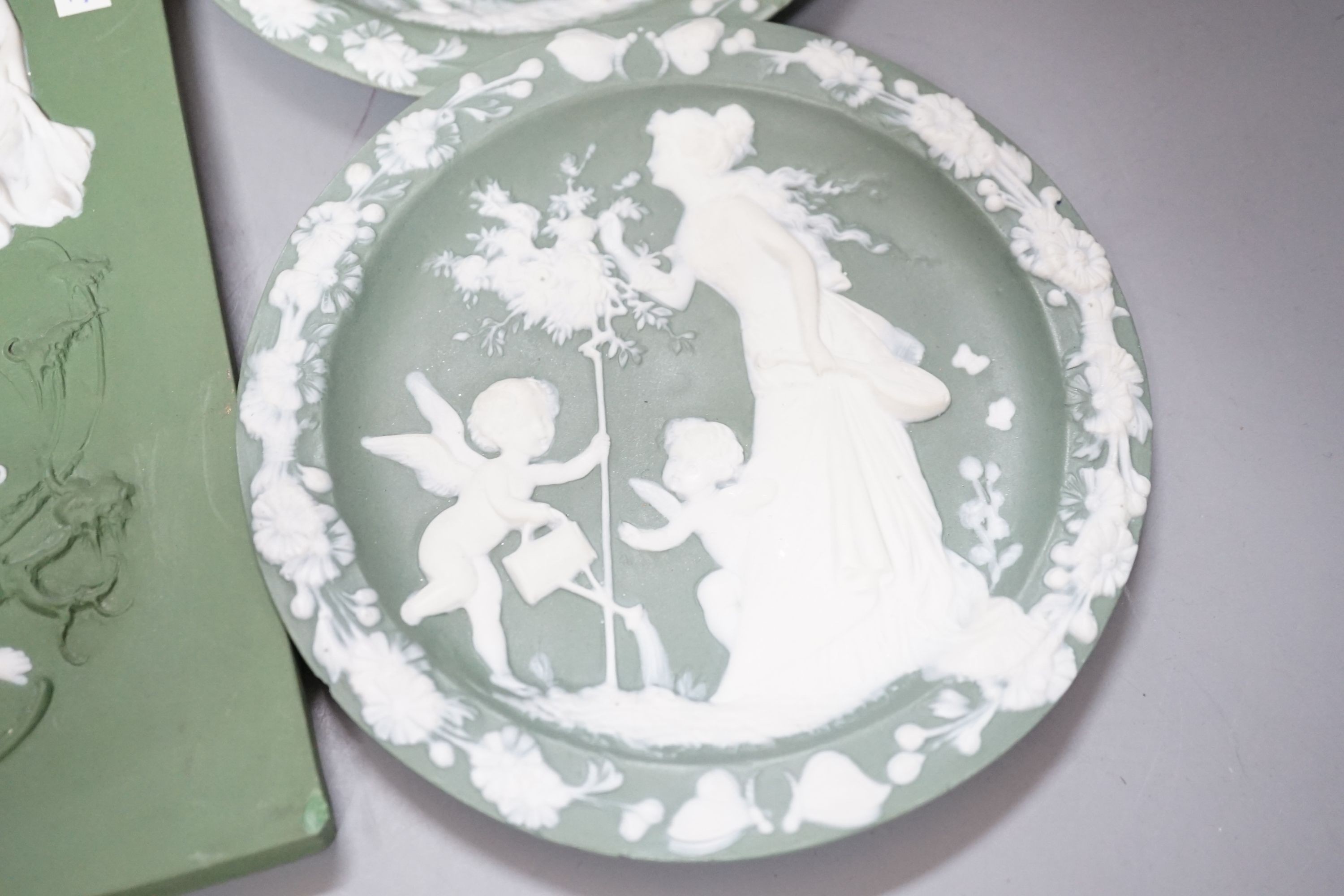 A collection of Limoges-type bisque plaques, largest 25.5 cm